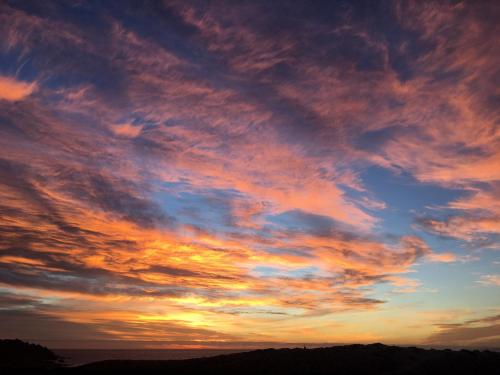 a sunset with colorful clouds in the sky at Kunza Kamanchacos in Punta de Choros