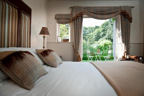 una camera con un letto e una grande finestra di Ravenwood Hall Hotel a Bury Saint Edmunds