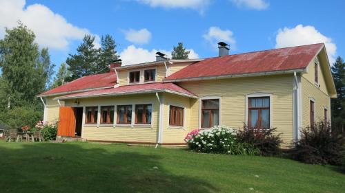 a yellow house with a red roof on a yard at Vanha-Pälsilä lakeside farm in Kuhmoinen