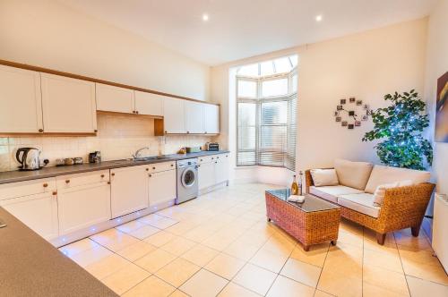 a kitchen and living room with a couch and a table at Elm Lodge in Plymouth