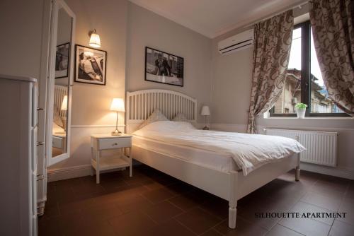 a bedroom with a white bed and a window at Presidency House Self Check-in Apartments in Sofia