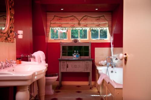 La salle de bains est pourvue de 2 lavabos, d'une baignoire et de toilettes. dans l'établissement Ravenwood Hall Hotel, à Bury St Edmunds