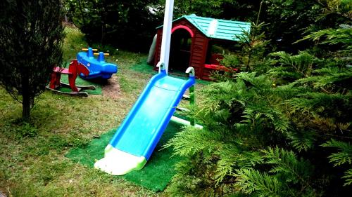 a playground with a slide and a play house at Willa Zamkowisko in Gołubie