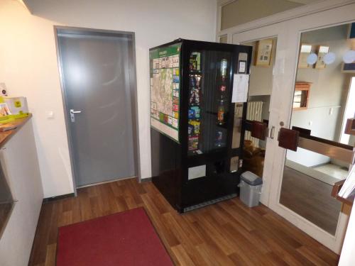 a black vending machine in a room with a door at Hotel Art Inn Dinslaken in Dinslaken