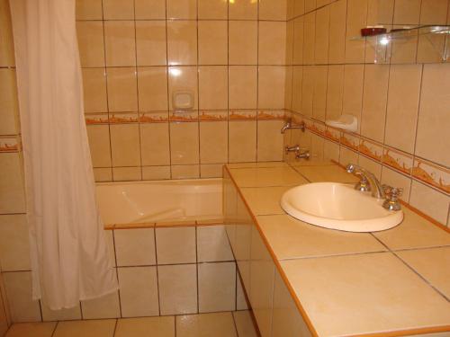 a bathroom with a sink and a bath tub at Hotel Sol del Oriente Iquitos in Iquitos