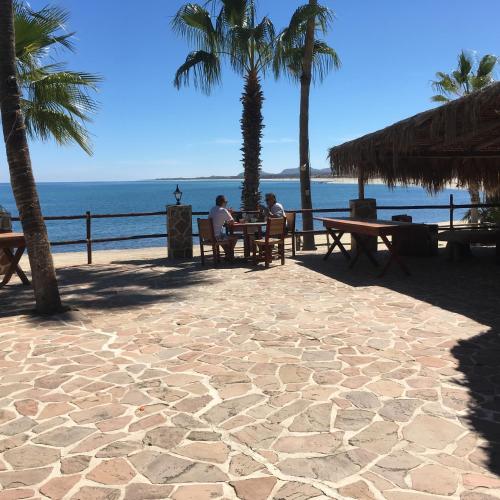 two people sitting at a table on the beach at Hotel Rancho Buenavista in Los Barriles