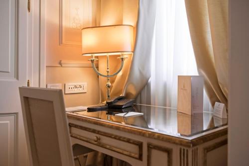 una lampada su un tavolo di vetro in una stanza di Hotel Armonia a Pontedera