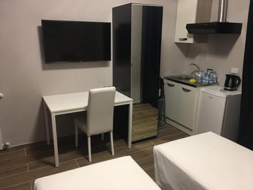 a small room with a desk and a tv on the wall at Favola Romana - Guest House in Rome