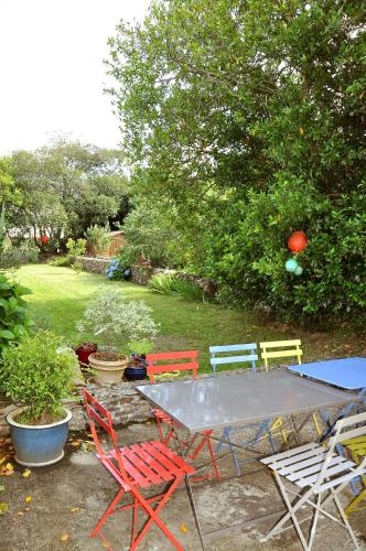 a picnic table with four chairs and a table with at Maison de Pêcheurs in Sarzeau