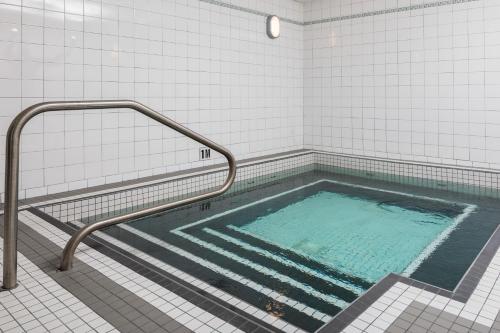 Super 8 by Wyndham Winnipeg West في وينيبيغ: حمام سباحة مع سكة اليد في الحمام