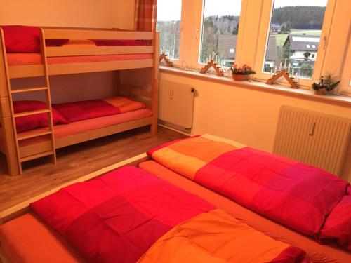 アンベルク・ブッフホルツにあるPöhlbergblick Annabergのベッドルーム1室(二段ベッド2台、窓付)が備わります。