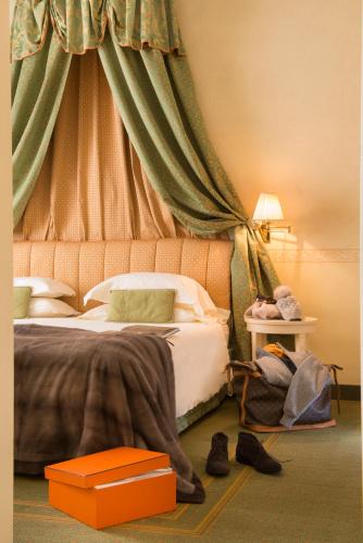 a bedroom with a bed with an orange canopy at Grand Hotel Royal E Golf in Courmayeur
