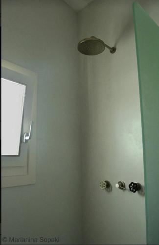 a bathroom with a shower with a light and a window at Spitaki Serifos Studio in Rámos