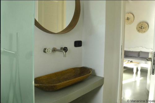 a bathroom with a wooden sink and a mirror at Spitaki Serifos Studio in Rámos