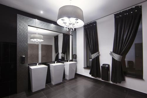 a bathroom with three urinals and a large mirror at Czarny Staw in Aleksandrów Łódzki