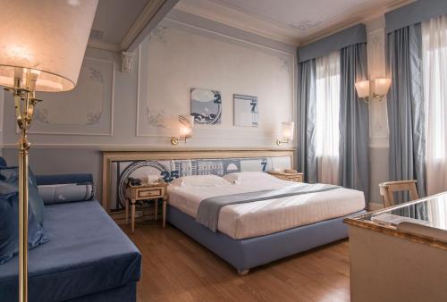 a bedroom with a bed and a couch at Hotel Armonia in Pontedera