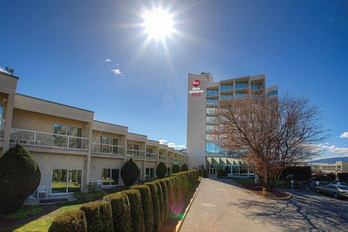 a building with the sun shining in the sky at Best Western Plus Kelowna Hotel & Suites in Kelowna