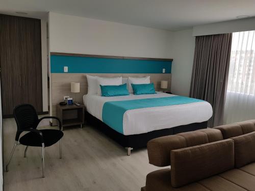 a bedroom with a large bed and a couch at Hotel Nivari Duitama in Duitama