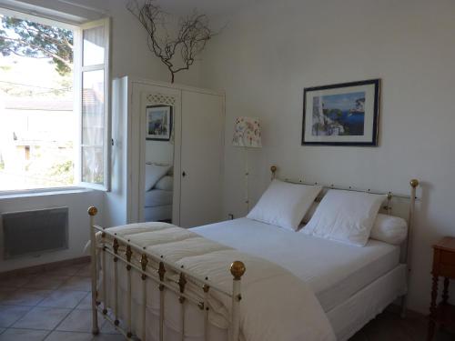 une chambre avec un lit avec des draps blancs et une fenêtre dans l'établissement Le coteau del aime, à Toulon
