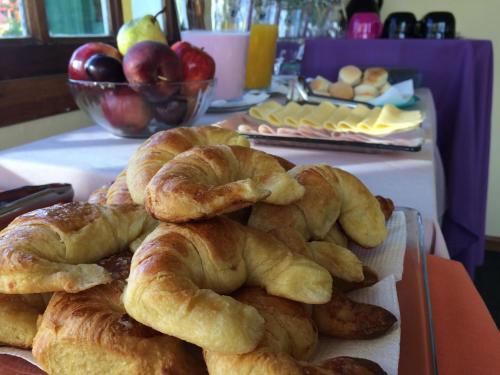 uma pilha de croissants e pães numa mesa em Hosteria Kupanaka em Ushuaia