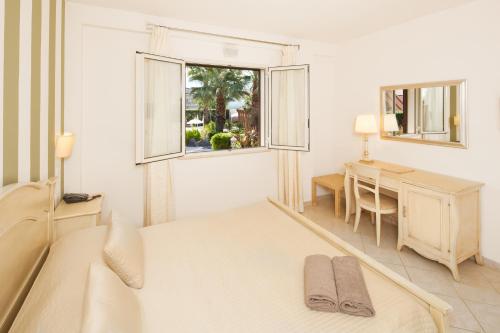 1 dormitorio con cama, escritorio y ventana en Alcantara Resort di Charme Adults Only, en Gaggi