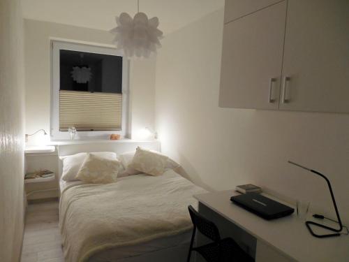 a bedroom with a bed and a desk and a window at Apartament Panorama in Iwonicz-Zdrój
