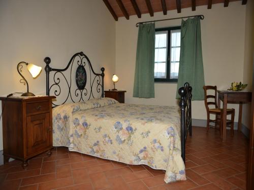 a bedroom with a bed and a table and a window at Agriturismo Musignano in Cerreto Guidi