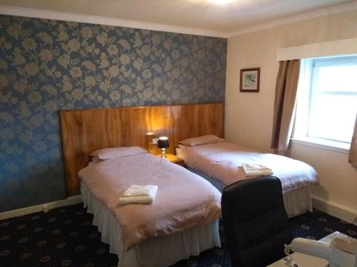 a hotel room with two beds and a window at Dalgair House Hotel in Callander