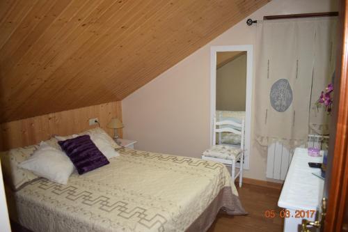 - une chambre avec un lit et un plafond en bois dans l'établissement Casa Rural Os Carballos, à Pontevedra