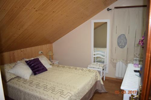 a bedroom with a bed and a wooden ceiling at Casa Rural Os Carballos in Pontevedra