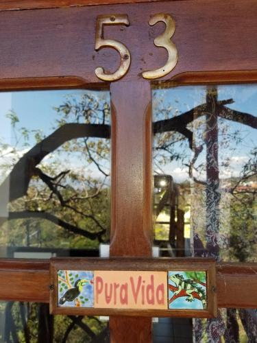 a wooden cross with a sign in front of a window at Hotel Monte Campana Heredia in Birrí