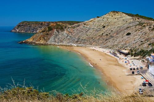 a beach with a group of people in the water at Casa Furt@do in Burgau