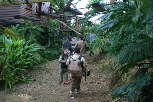 a group of people walking through a forest at Hotel Monte Campana Heredia in Birrí