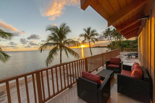 a balcony overlooking a beach with a view of the ocean at Hotel Molokai in Kaunakakai