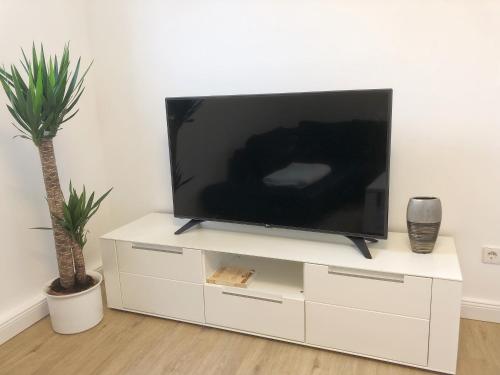a flat screen tv sitting on top of a white dresser at Hugo18 Boardinghouse in Kandel