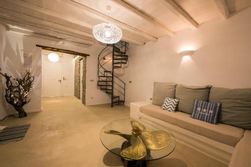 a living room with a couch and a glass table at Evlalia Studios & Villas in Skopelos Town