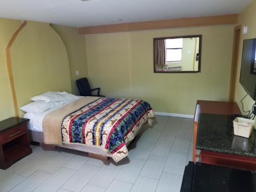 a bedroom with a bed and a desk and a window at Budget Motel in Orlando