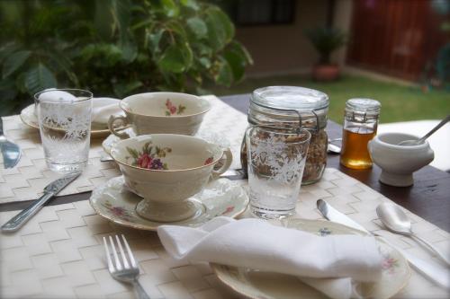 a table with cups and saucers on a table at Villa Balthazar in Búzios
