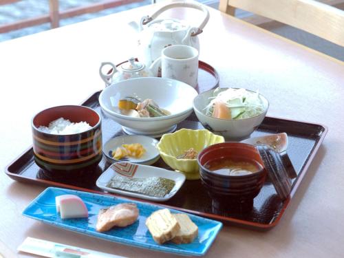 a tray of food with bowls and plates of food at momijigawa onsen in Naka