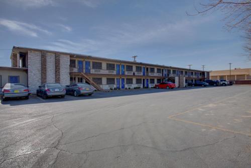 a parking lot with cars parked in front of a building at Carlsbad Inn , New Mexico in Carlsbad