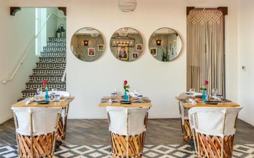a dining room with two tables and two mirrors at La Serena Villas in Palm Springs