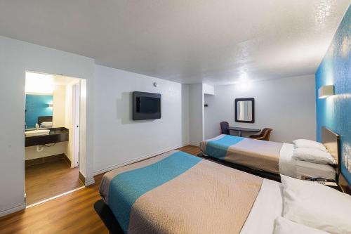 a hotel room with two beds and a television at Motel 6-Grand Prairie, TX - Interstate 30 in Grand Prairie
