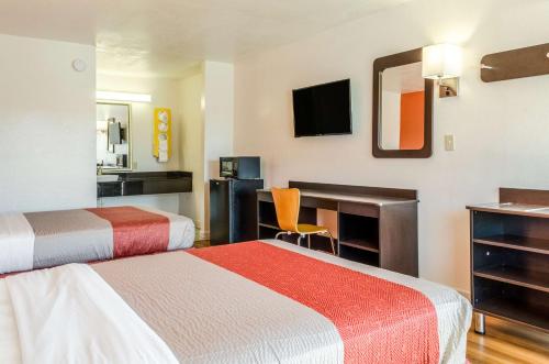 ein Hotelzimmer mit 2 Betten und einem Schreibtisch in der Unterkunft Motel 6-Saraland, AL in Saraland