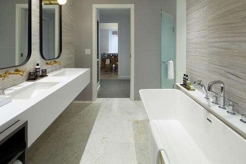a bathroom with three sinks and two mirrors at Andaz Ottawa Byward Market-a concept by Hyatt in Ottawa