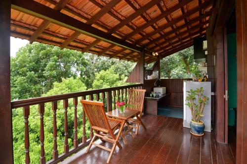 a porch with two chairs and a table and a refrigerator at The Dusun in Seremban