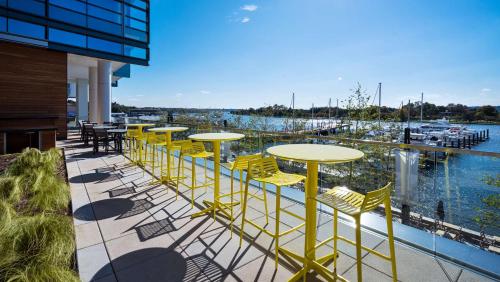 a row of yellow tables and chairs on a balcony at Hyatt House Washington DC/The Wharf in Washington