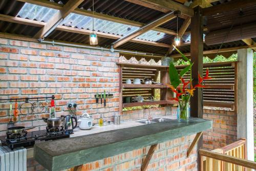 a brick kitchen with a sink and a stove at The Dusun in Seremban