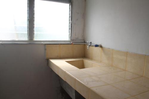 an empty bathroom with a window and a tiled floor at Casaoro Homestay in Puerto Princesa City