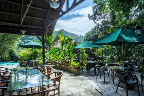 a patio with tables and chairs and a pool at The Dusun in Seremban