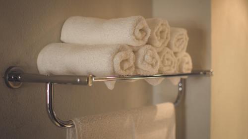 um grupo de toalhas num toalheiro na casa de banho em Hotel Belisario INN em Guadalajara